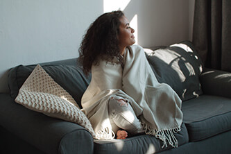Woman bundled up on couch