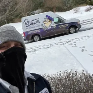 A man wearing a face mask standing in front of a Blanton’s Van.
