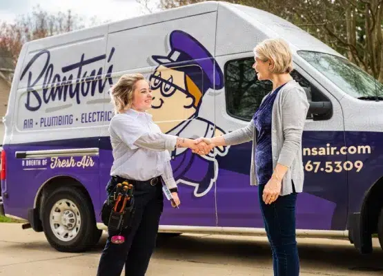Blanton's technician shaking a customer's hand, both standing in front of a Blanton's service truck