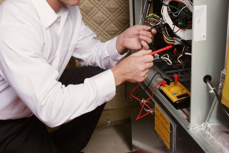 HVAC technician performing a maintenance service on a residential furnace 