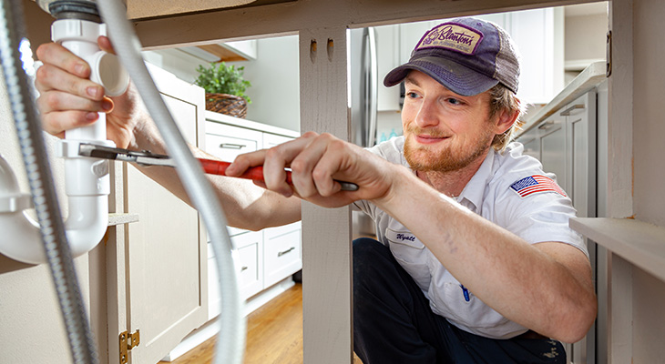 Close-up of an employee repairing pipes.