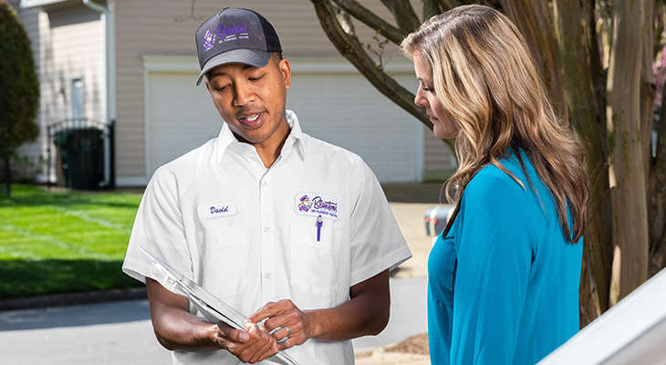 Heating and air conditioning technician explaining repair details to a homeowner.